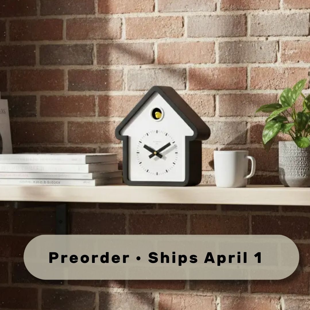 Preorder - House White Cuckoo Clock on shelf with books, mug, and plant, showcasing Dutch design and functional design style.