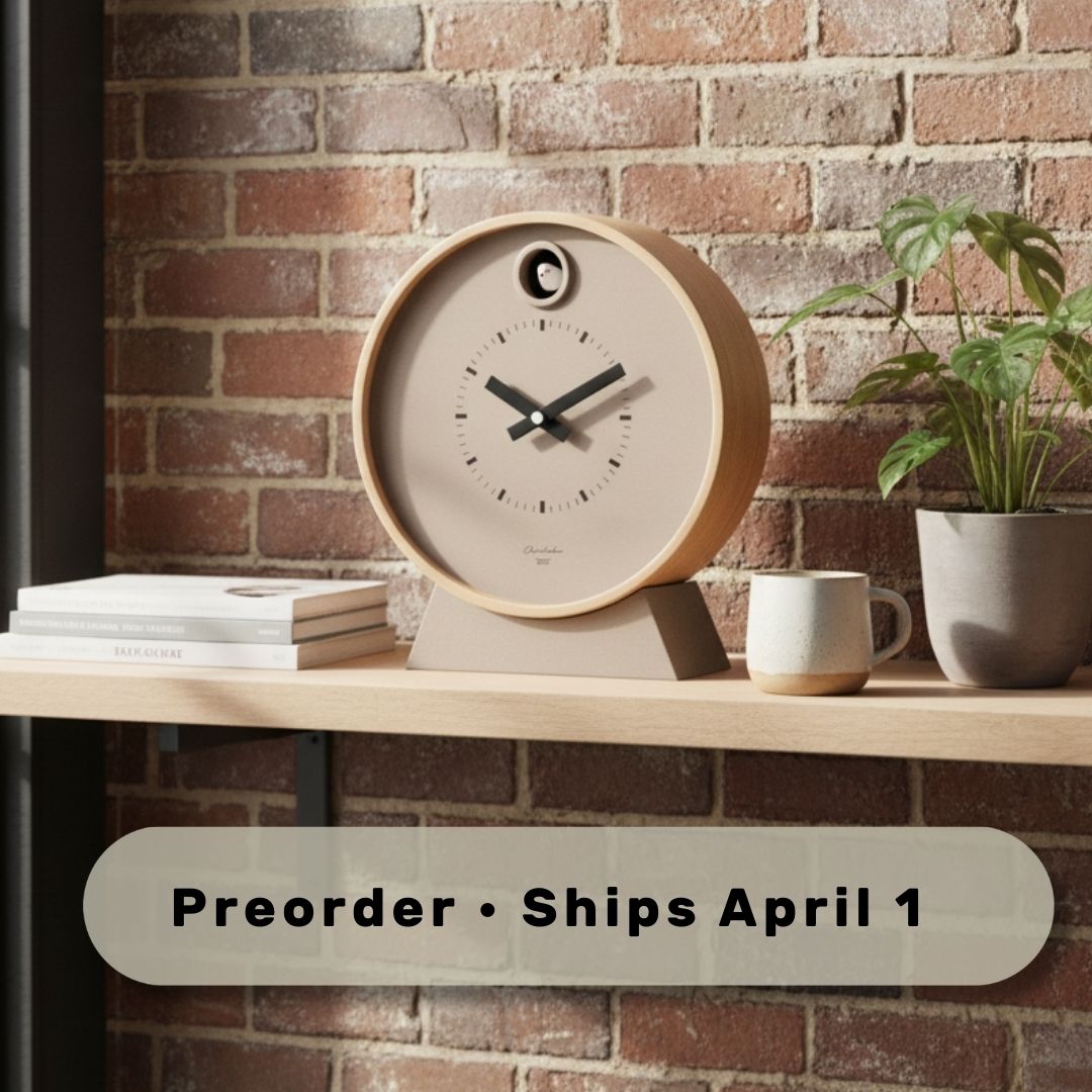 Wooden clock on a shelf with a plant and books against a brick wall, preorder text overlay.