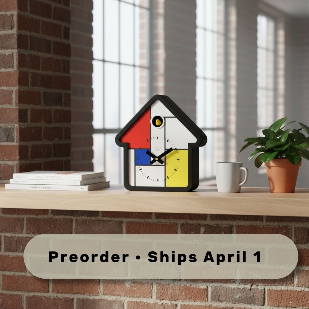 Preorder - Mondrian Cuckoo Clock on wooden shelf with books, plant, and mug showcasing Dutch Design and Functional Design.
