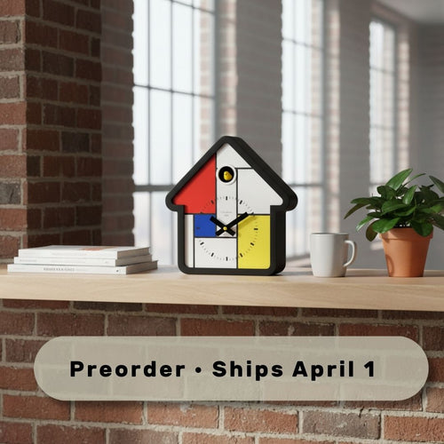Preorder - Mondrian Cuckoo Clock on wooden shelf with books, plant, and mug showcasing Dutch Design and Functional Design.