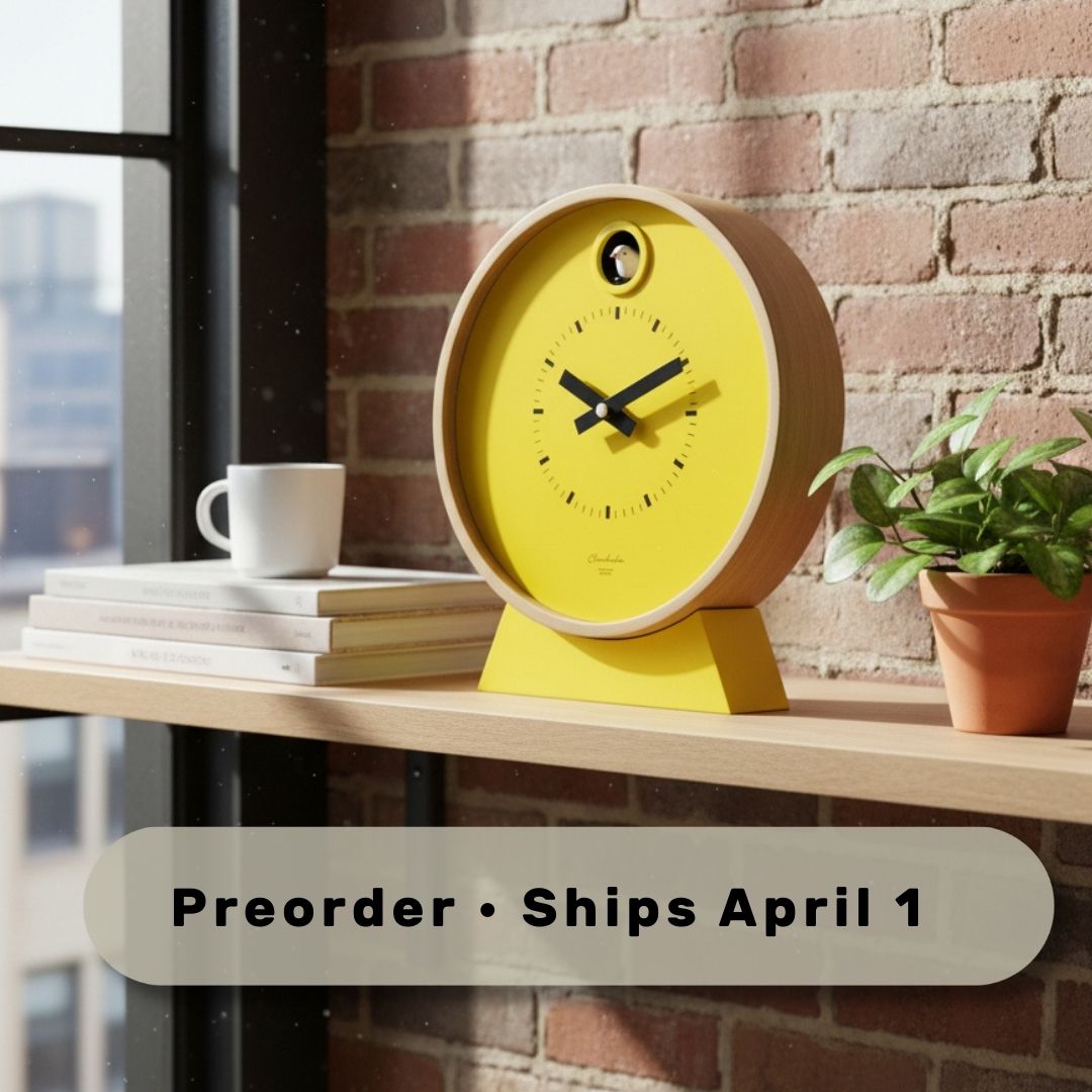 Preorder - Dot Yellow Cuckoo Clock with bright yellow face, wooden frame, and minimalist design on shelf in modern room. Dutch Design. Functional Design.