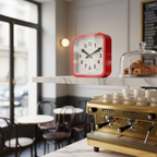 Big Railway Red Square Kitchen Wall Clock in red with minimalist design on marble shelf in modern café interior, Dutch Design.