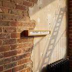 Preorder - Texttime 2.0 Bamboo Text Flip Clock mounted on rustic wall with Dutch Design and Functional Design style