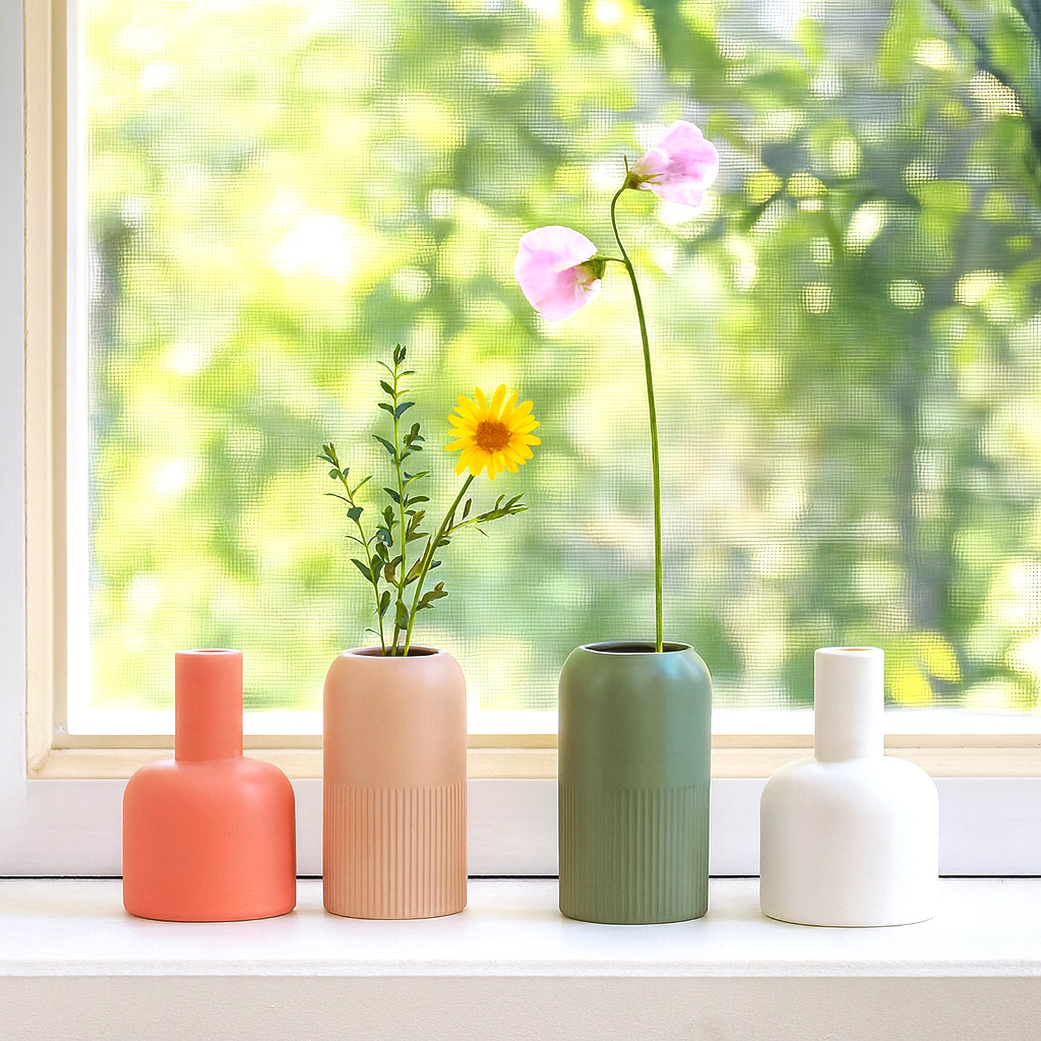 Four colorful ceramic vases arranged on a windowsill showcasing Fusion Flip Reversible Ceramic Vase Set – Small Dutch Design Functional Design