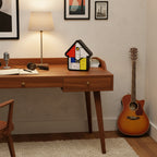 Preorder - Mondrian Cuckoo Clock on wooden desk with lamp in minimalist room showcasing Dutch Design and Functional Design.