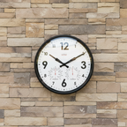 Factory Black Outdoor Clock mounted on a stone wall with temperature and humidity gauges Dutch Design Functional Design