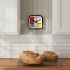 Mondrian Square Kitchen Wall Clock with Dutch Design hangs on wall above steaming fresh bread, Functional Design modern kitchen clock.