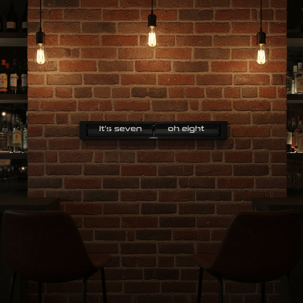 Preorder - Texttime 2.0 BonB Text Flip Clock displayed on brick wall with warm lighting, Dutch Design, Functional Design.