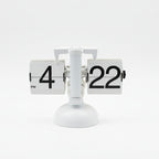 Digital clock displaying the time '4:22' on a wooden surface with blinds in the background.